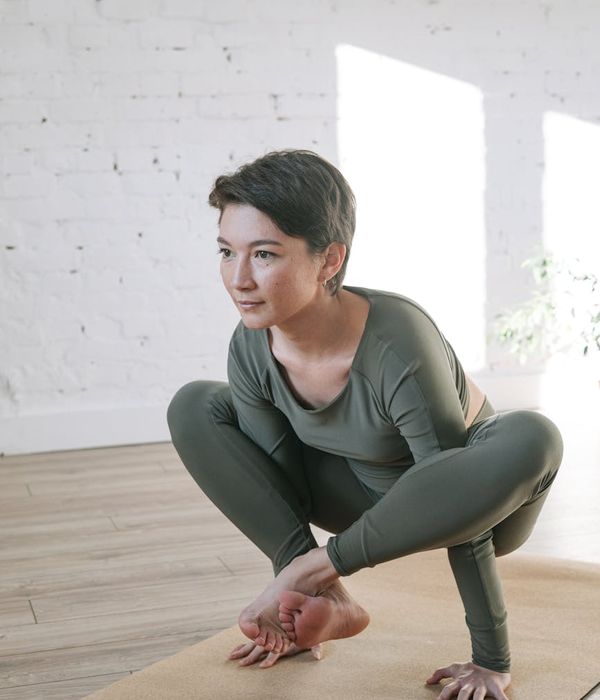 Woman in a calm yoga pose in a bright, airy room.